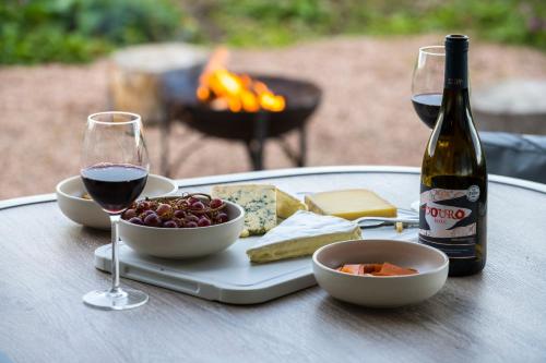 a table with a plate of food and a bottle of wine at Off Grid Travel at Cambo Estate in St. Andrews