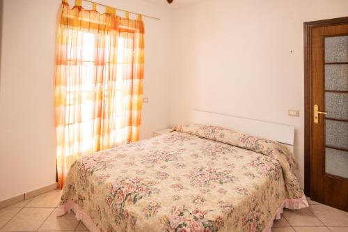 a bedroom with a bed with a floral bedspread at Il Sole di Scalea in Scalea