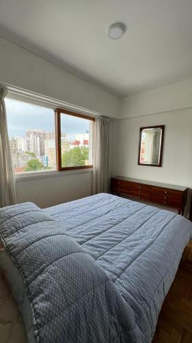 ein Schlafzimmer mit einem großen Bett und einem großen Fenster in der Unterkunft Check and Home - Rawson - 4 huéspedes amplio en el centro in Mar del Plata