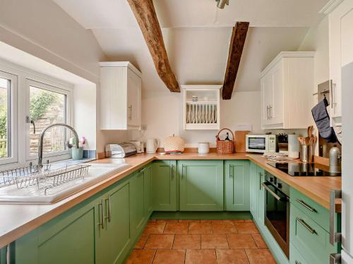 a kitchen with green cabinets and a sink at 2 bed property in Gresham 75916 in Aylmerton