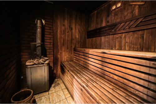 eine Sauna mit Herd in einem Holzzimmer in der Unterkunft Садиба на Кодимі 