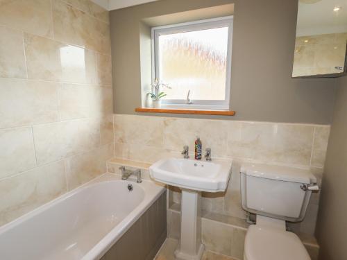 een badkamer met een wastafel, een toilet en een bad bij 25 Maes Collen in Llangollen
