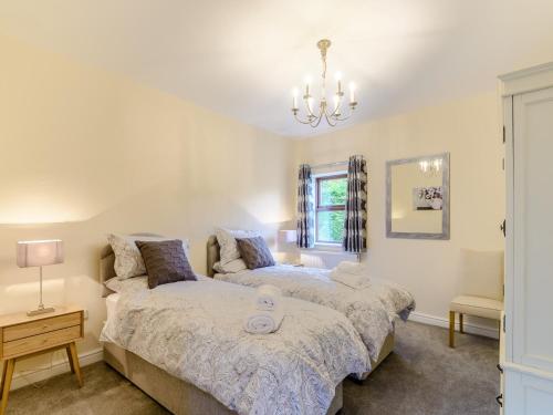 a bedroom with two beds and a chandelier at 2 bed in Hamsterley 80004 in High Etherley