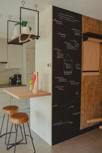una pizarra con el menú en la pared de una cocina en De Pluktuin, en Kortessem