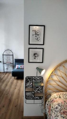 ein Wohnzimmer mit einem Bett und Bildern an der Wand in der Unterkunft Pane e Tulipani, cozy apartment near city center in Turin