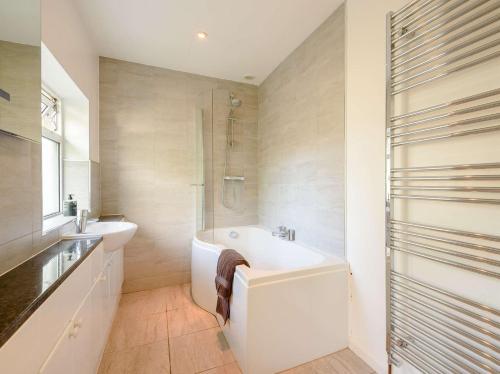 a bathroom with a tub and a sink and a shower at 3 bed in Glasbury-on-Wye BN289 in Glasbury