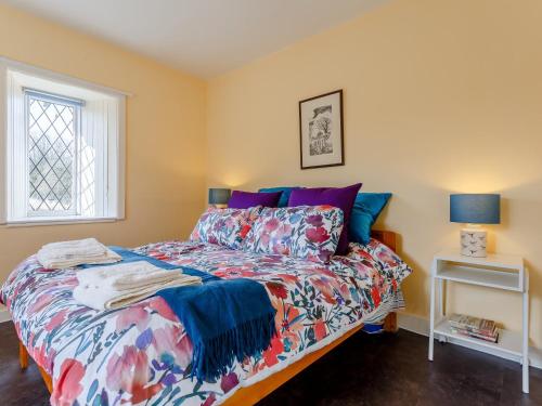 een slaapkamer met een bed met een kleurrijk dekbed bij 2 bed property in Kirriemuir 77494 in Kirriemuir