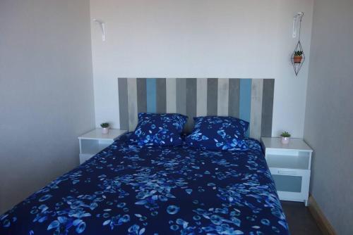 - une chambre avec un lit bleu et 2 oreillers dans l'établissement Appartement SUPERBE VUE MER avec balcon, WIFI, à TREGASTEL - Réf 93, à Trégastel