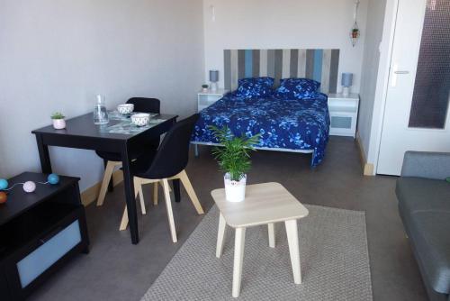 une petite pièce avec un lit, une table et des chaises dans l'établissement Appartement SUPERBE VUE MER avec balcon, WIFI, à TREGASTEL - Réf 93, à Trégastel