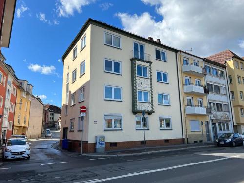 a white building on a city street with cars parked at Stilvolle Wohnung an der Alten Mainbrücke in Würzburg