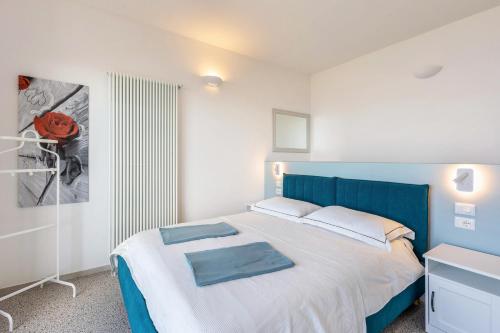 een slaapkamer met een bed met een blauw hoofdeinde bij Casa Serena in Torri del Benaco