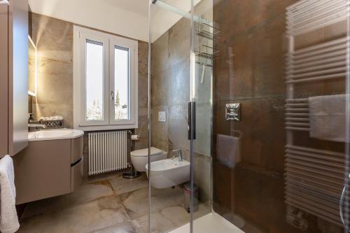 een badkamer met een wastafel, een toilet en een douche bij Casa Serena in Torri del Benaco