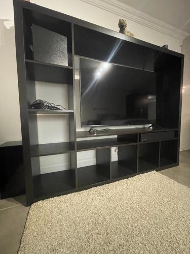a black entertainment center with a large screen television at 50A Green Lane in Cranford