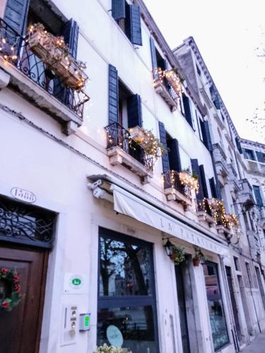 a white building with windows and balconies on a street at B&B Patatina in Venice