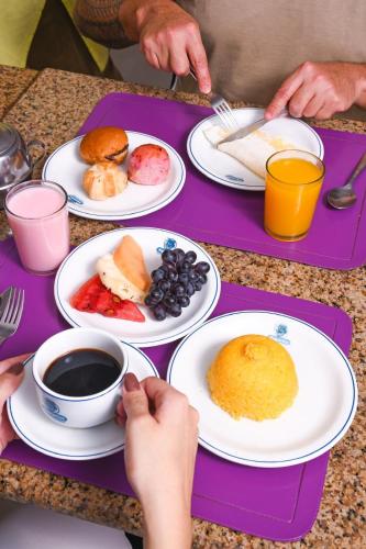 a purple tray with plates of breakfast food on it at Hotel Aquarius in Fortaleza