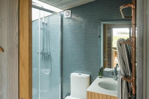 La salle de bains est pourvue d'une douche, de toilettes et d'un lavabo. dans l'établissement Off Grid Travel at Cambo Estate, à St Andrews