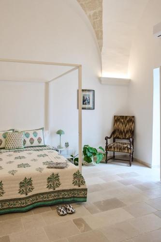 a bedroom with a bed and a chair at Silentio Suite N2-Ostuni-Jacuzzi in Ostuni