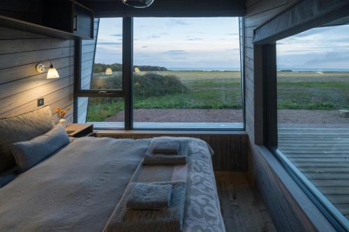 łóżko w pokoju z dużym oknem w obiekcie Off Grid Travel at Cambo Estate w mieście St Andrews