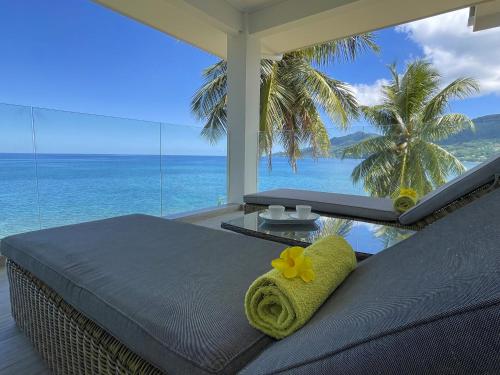 a bedroom with a bed with a view of the ocean at VallonEnd Beachfront villa with excellent view in Bel Ombre