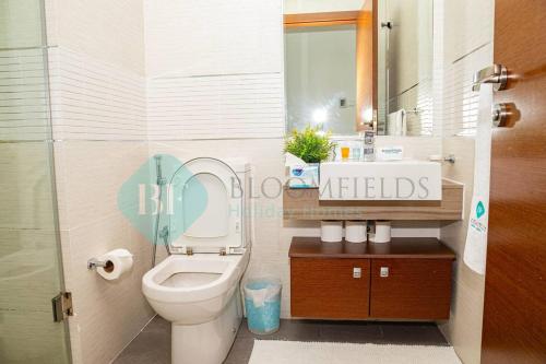 La salle de bains est pourvue de toilettes et d'un lavabo avec miroir. dans l'établissement Stunning Studio In Gate Tower, à Abu Dhabi