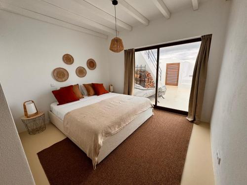 a bedroom with a bed and a large window at Villas Mont-Blanc in Reguengos de Monsaraz