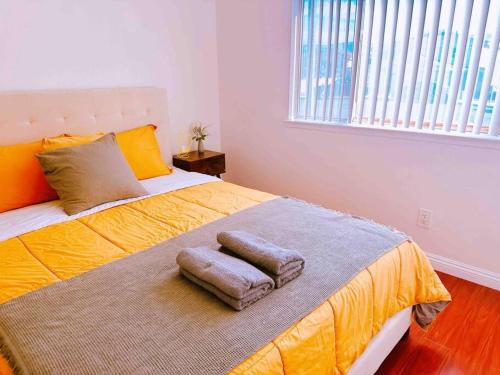 a bedroom with a bed with two towels on it at Charming 3BR Retreat near Disneyland Downtown LA! in Rowland Heights