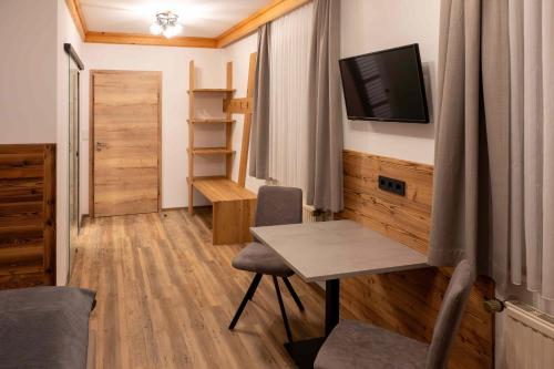 a small room with a desk and a tv on the wall at Pension Kreischberg Mayer in Sankt Lorenzen ob Murau