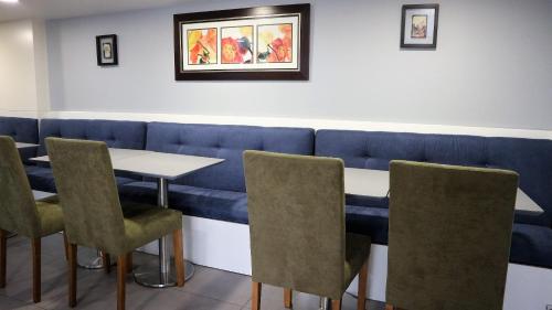 a dining room with a blue bench and a table and chairs at Hotel Senhor de Matosinhos in Matosinhos