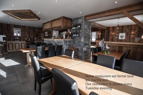 a restaurant with wooden tables and chairs and a bar at Hotel Le Grand Tetras in Morzine