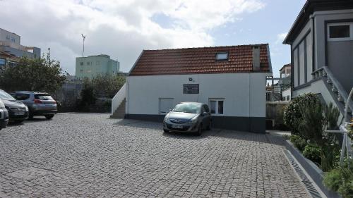 a small car parked next to a white building at Hotel Senhor de Matosinhos in Matosinhos