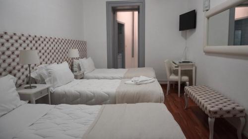 a hotel room with two beds and a television at Hotel Senhor de Matosinhos in Matosinhos