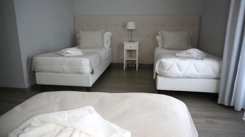 a room with two beds and a couch and a table at Hotel Senhor de Matosinhos in Matosinhos