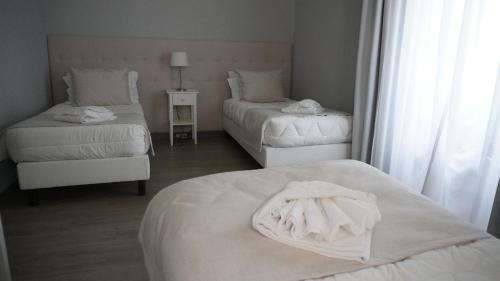 a hotel room with two beds and a chair at Hotel Senhor de Matosinhos in Matosinhos