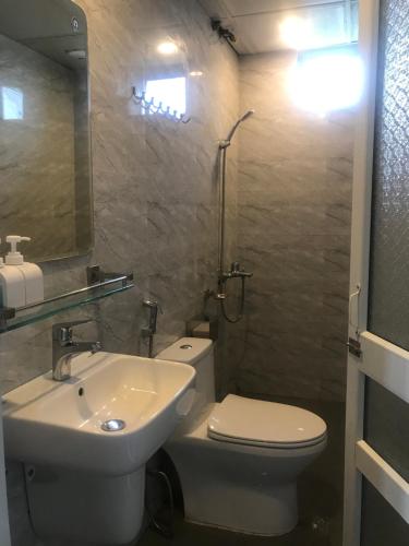 Un baño con un inodoro blanco y un lavabo. en Hải Lê Tam Coc Happy Homestay, en Ninh Binh