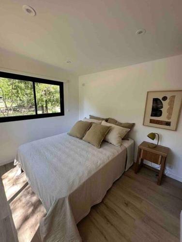 um quarto com uma cama grande e uma janela em Cabañas en medio del bosque em Chascomús