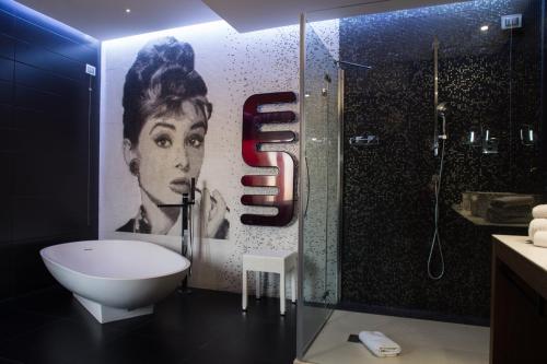 uma casa de banho com um chuveiro, um WC e um mural. em Divina Luxury Hotel em Roma