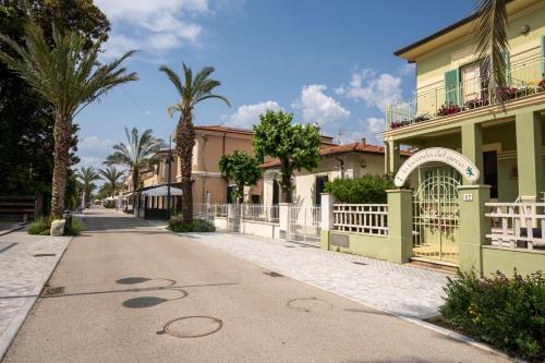 an empty street with palm trees and houses at La Locanda del Geco in Marina di Pietrasanta
