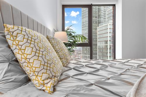 a bedroom with a bed with pillows and a window at Central London New 2 bedroom flat Riverview Balcony in London