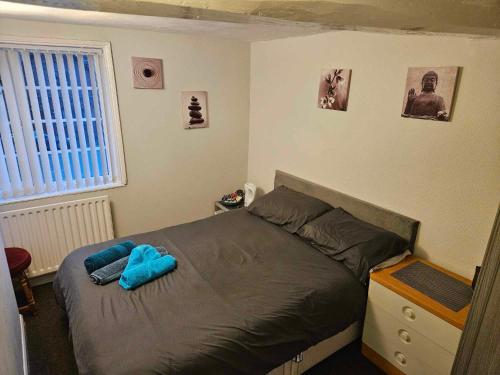 a bedroom with a bed with blue sheets and a window at The White Lion Inn in Brinklow