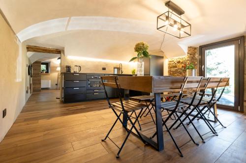 a kitchen with a dining room table and chairs at Chalet l'ozio creativo in Castelnuovo Nigra