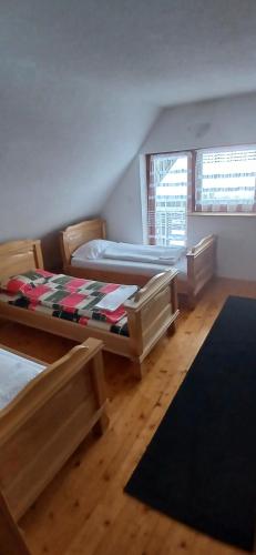 a bedroom with two beds and a rug at Samostanska kuća in Fojnica