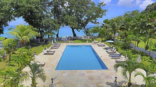 a swimming pool with lounge chairs and a resort at Chateau Elysium in Beau Vallon