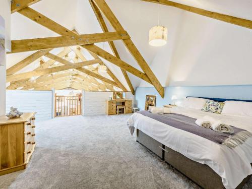 a bedroom with a large bed and exposed beams at 6 Bed in Great Torrington 81519 in Great Torrington