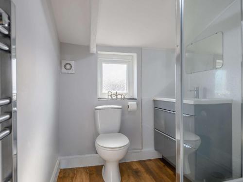 a white bathroom with a toilet and a sink at 2 Bed in Reepham 85833 in Cawston