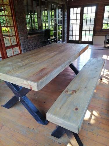 a wooden picnic table with two benches on a wooden floor at Traveller's dream in Graskop