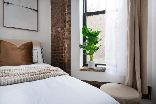 ニューヨークにある153-1G Newly Renovated 2BR Lower East Sideのベッドルーム1室(ベッド1台付)、窓に植物