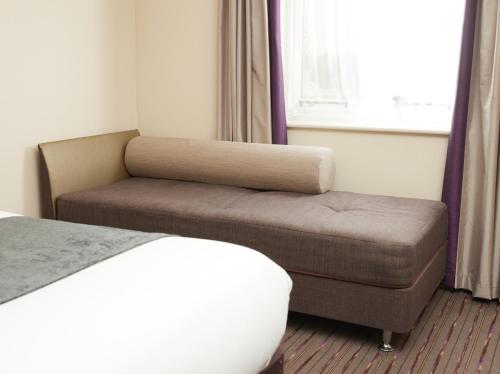 a bedroom with a bed and a couch and a window at The Quays by Greene King Inns in Northampton