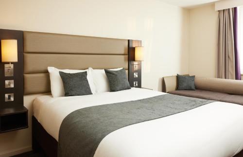 a bedroom with a large white bed with pillows at The Quays by Greene King Inns in Northampton