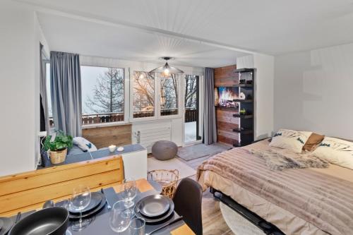 a bedroom with a bed and a table with chairs at Appartement rénové avec sauna privé in Saas-Fee