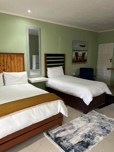 Pokój hotelowy z 2 łóżkami i lustrem w obiekcie Falaza Lodge Jozini 